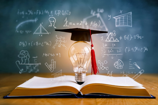 drei Frauen sitzen und stehen im Büro um einen Arbeitsplatz herum und schauen interessiert in einen Screen